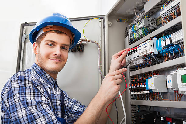 Side view of male technician examining fusebox with multimeter probe