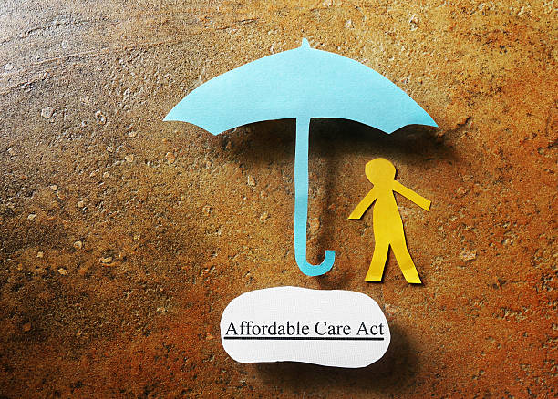Paper person under Affordable Care Act umbrella - Obamacare concept